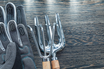 Gardening rake trowel fork protective gloves on wooden board