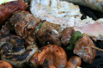 A set of meats baked on the grill during a family picnic in free time. Summer relaxation in the open air.