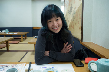 Beautiful female traveller smiling in a Japanese restaurant ready to eat