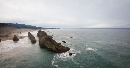 Aerial panoramic view of the Highway at Pacific Ocean Shore during a cloudy winter morning. Taken in Oregon Coast, North America.