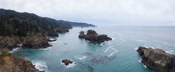 Aerial panoramic view of the Highway at Pacific Ocean Shore during a cloudy winter morning. Taken in Oregon Coast, North America.