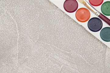 Paint set on a light stone background, close up, top view