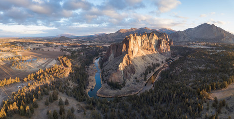 Fototapeta premium Aerial panoramic view of a beautiful landmark, Smith Rock, famous for rockclimbing. Taken in Redmond, Oregon, America, during a vibrant sunrise.