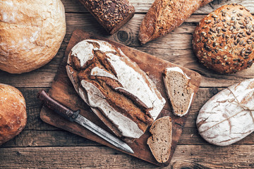 Delicious fresh bread on wooden background