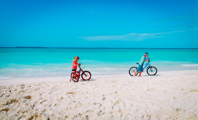 Fototapeta premium little boy and girl ride bike on beach