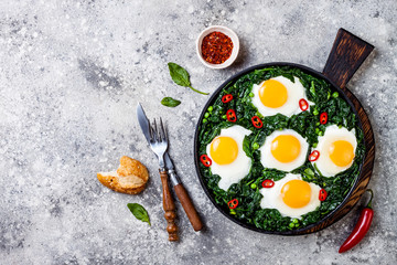 Green shakshuka with spinach, kale and peas. Healthy delicious breakfast. Top view, overhead, flat lay, copy space