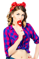 Portrait of beautiful young woman with vintage make-up and hairstyle with lollipop