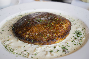 National dish of Belarus. Dranik with pork in sour-mushroom sauce.
