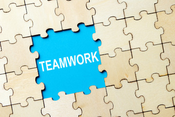 Jigsaw puzzle pieces with word teamwork on grey background