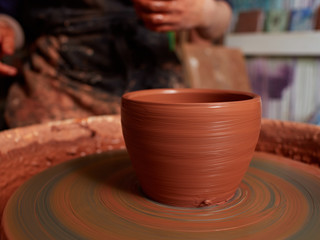 Forming a clay mug on a potter's wheel.