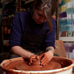 Forming a clay mug on a potter's wheel.