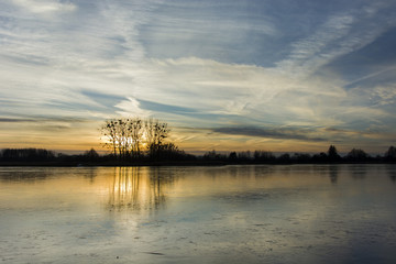 Obraz premium Clouds and sunset over a frozen lake