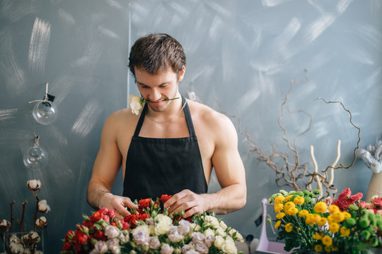 image of handsome forist matching flowers and touching them