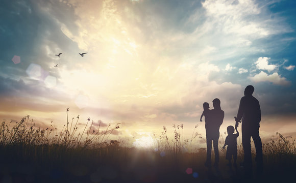 International migrants day concept: Father, mother and two son over meadow autumn sunset background