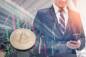 The double exposure image of the business man using a smartphone overlay with bitcoin and binary code image. the concept of cryptocurrency, blockchain, internet of things and future life