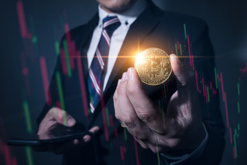 The double exposure image of the business hold a bitcoin and smartphone overlay with stock graph line image. the concept of cryptocurrency, blockchain, trading, internet of things and future life