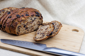 cutting fruit bread with knife on the wooden cutting board