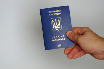 Blue Ukrainian passport in the hands of a man. Isolate