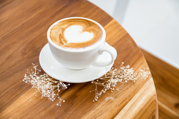 single coffee cup on wood table,heart shape latte art concept,love signature with coffee.
