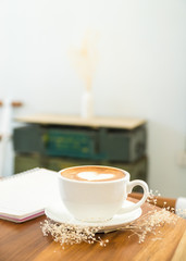 single coffee cup on wood table,heart shape latte art concept,love signature with coffee.