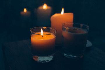 Obraz na płótnie Canvas Three burning candles on table, cozy rainy day an home