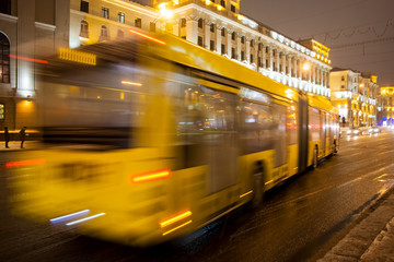 Fototapeta na wymiar Blurred bus traffic on the avenue at night