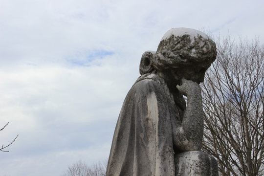 Stone marble religious statue in cemetery 