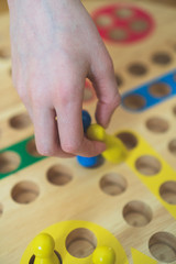 Child playing Ludo board game. Close-up view.