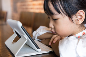 Asian Chinese little girl playing tablet computer
