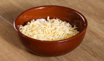 bowl with old Dutch grated cheese on wooden background