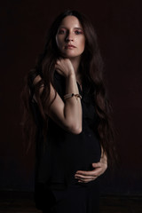 Naklejka premium stylish portrait of pregnant woman on dark background