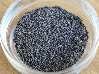 bowl with poppy seed on wooden backround