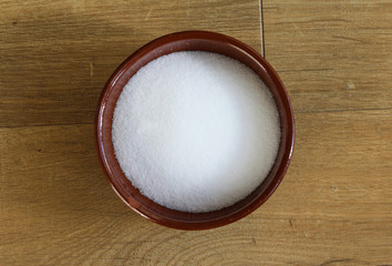 bowl with white salt on wooden background