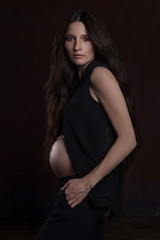 stylish portrait of pregnant woman on dark background