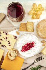 Various types of cheese with wine on a light background