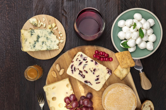 Various types of cheese on rustic background with wine and copyspace