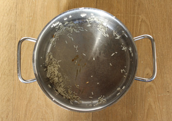Dirty rice pan on wooden background