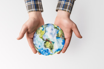 partial view of man holding handmade globe in hands isolated on grey, environment protection concept