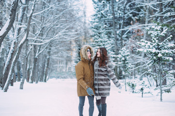 Naklejka premium Guy and girl walk ,have fun in the forest in winter
