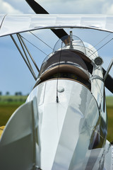 Old airplane - biplane at the airfield, back side view. Air concept of retro aviation. Wings, tail...