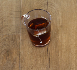 Glass of Moroccan mint tea with tea bag on wooden background