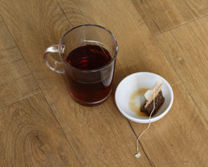 Glass of Moroccan mint tea with tea bag on wooden background