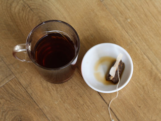 Glass of Moroccan mint tea with tea bag on wooden background