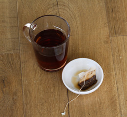 Glass of Moroccan mint tea with tea bag on wooden background