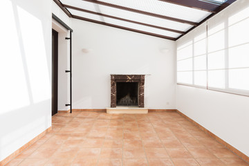 Unfurnished room with large windows on the ceiling and fireplace