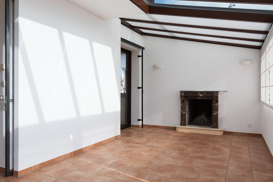 Unfurnished room with large windows on the ceiling and fireplace