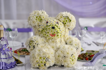 Teddy bear made of flowers on wedding table