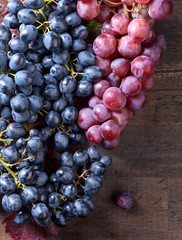 Grapes bunch with leaves on a old wooden background.