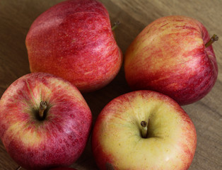 Fresh red and yellow royal gala apples on wooden background
