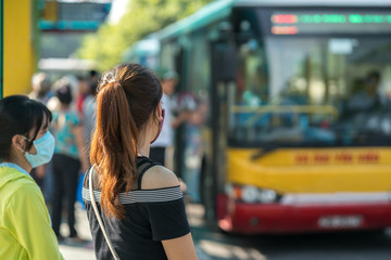 Young girl waiting for bus at bus station. Closeup.